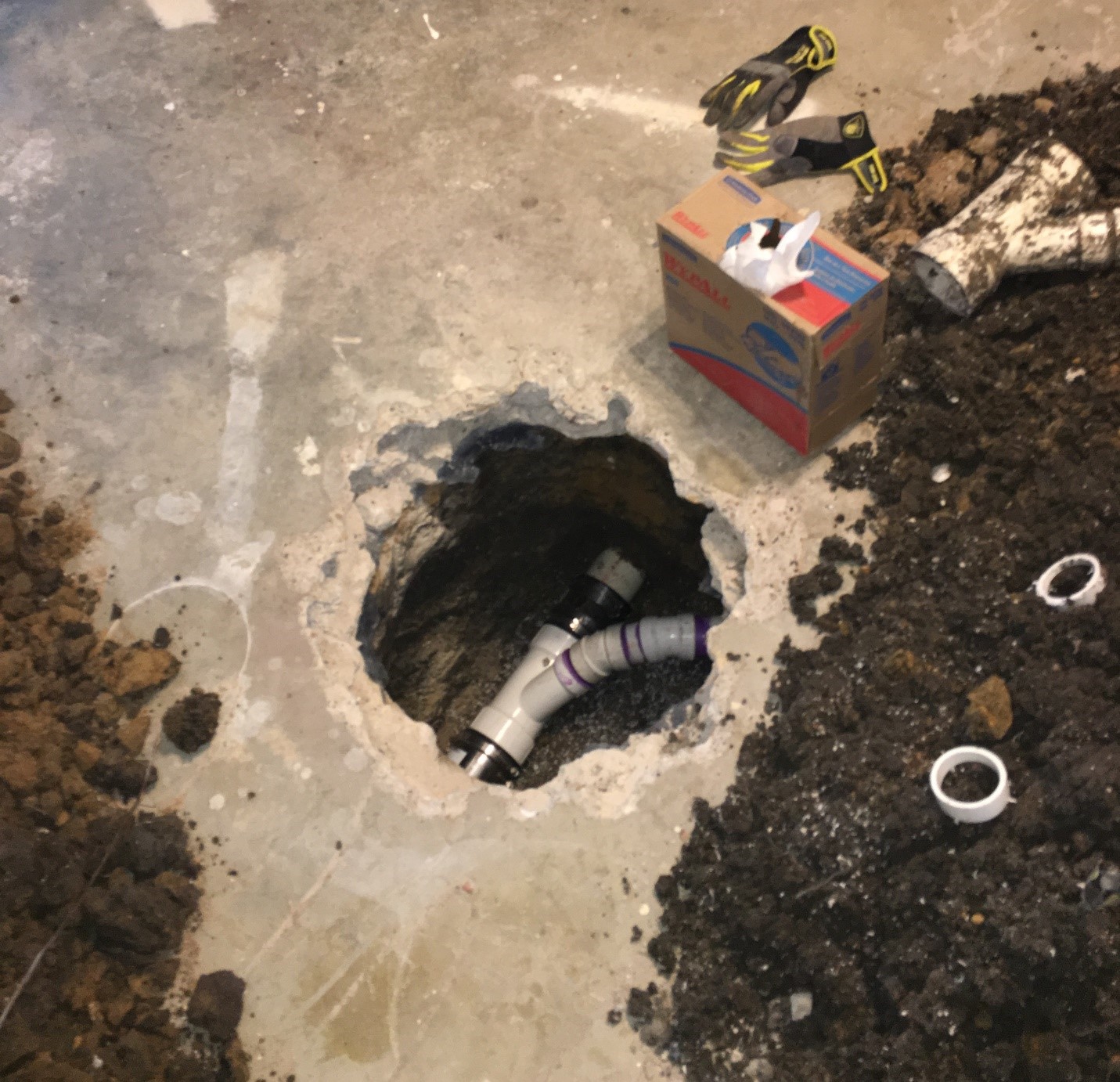 A broken pipe under a slab of concrete.