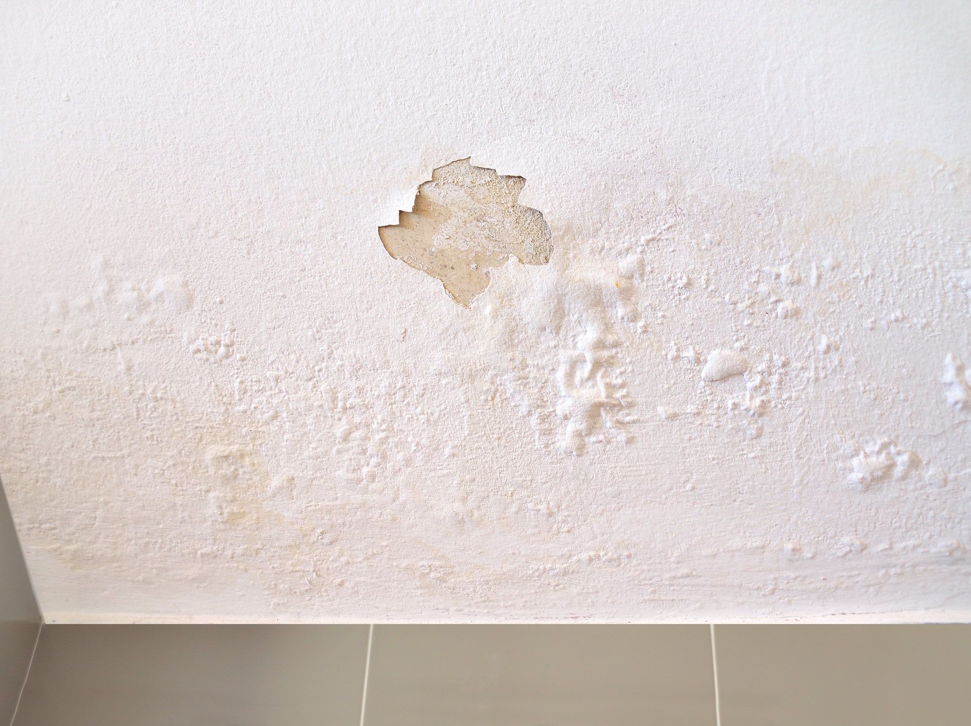 Slab leak damage on a white wall.